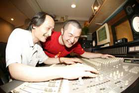 スタジオ録音調整室で音楽製作に取り組む村上氏とスタッフの五十嵐氏